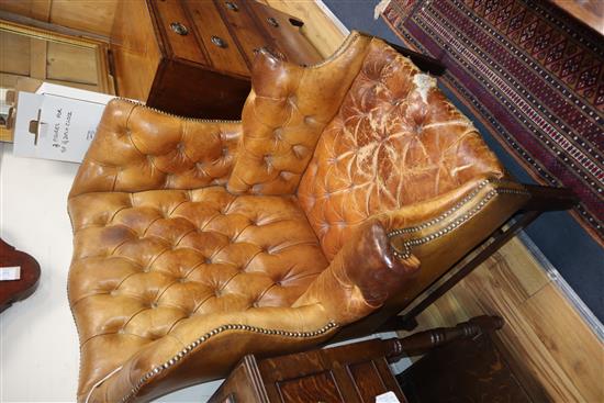A pair of leather tan wing armchairs